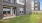 Large attached yard with green grass and patio with orange chairs